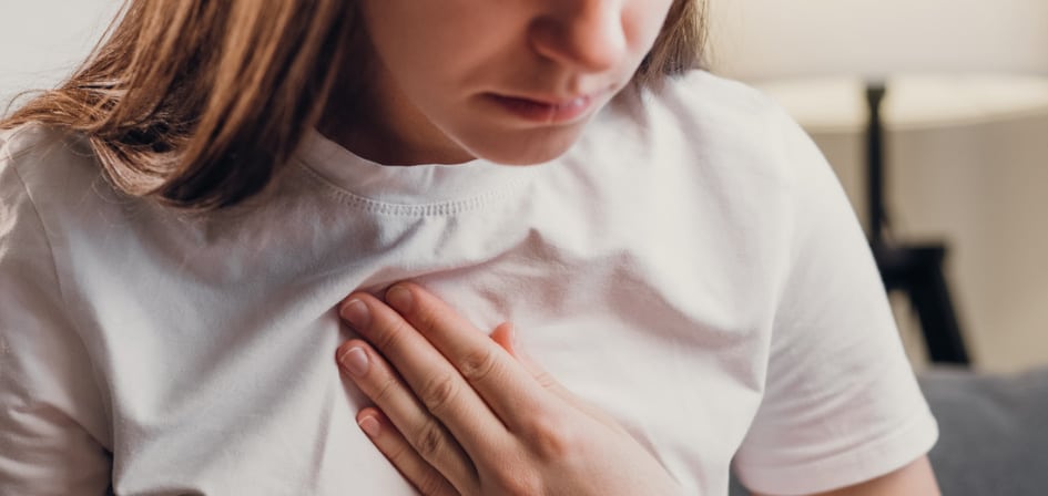 How to Manage Anxiety - an image of half a womans face, with her hand on her chest, indicating she is experiencing anxiety induced heart palpitations.