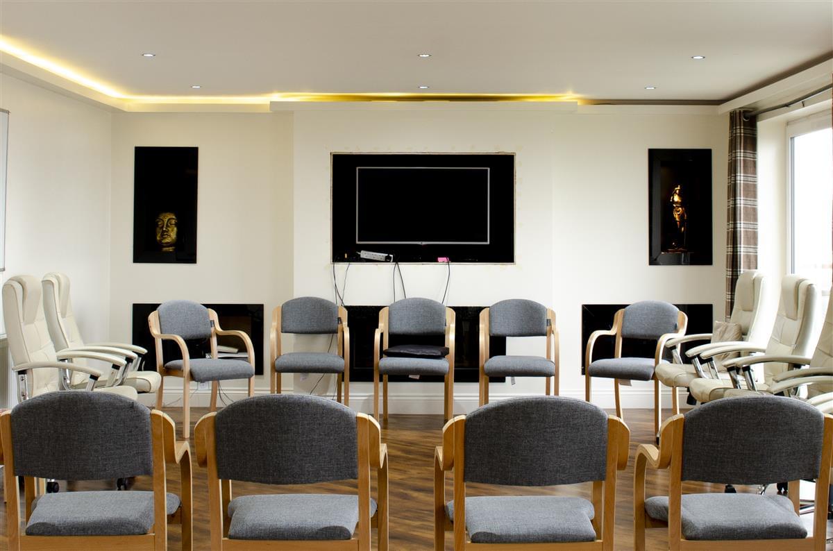 Large, open plan group room with a circle of chair for residents to take part in group therapy sessions with one another, at rehabilitation residential treatment centre, Ocean Recovery