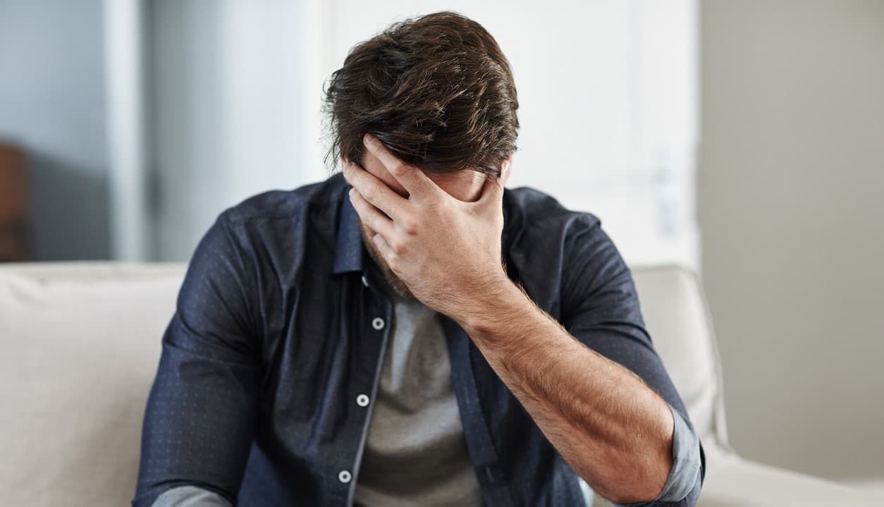 Man holding head in hands from cocaine abuse and mental health problems