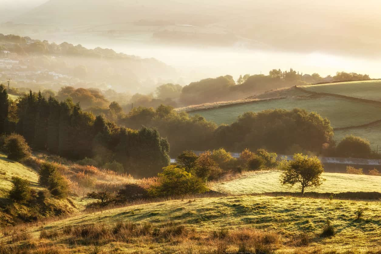 Countryside with sunrise and mist in the distance