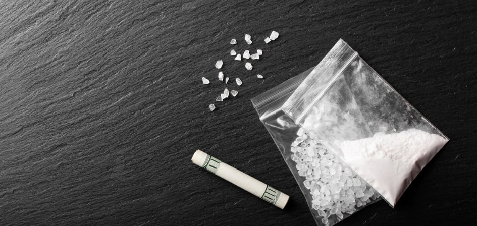 Can You Overdose on Coke. An image of cocaine powder and crystals in a plastic bag on a black background.