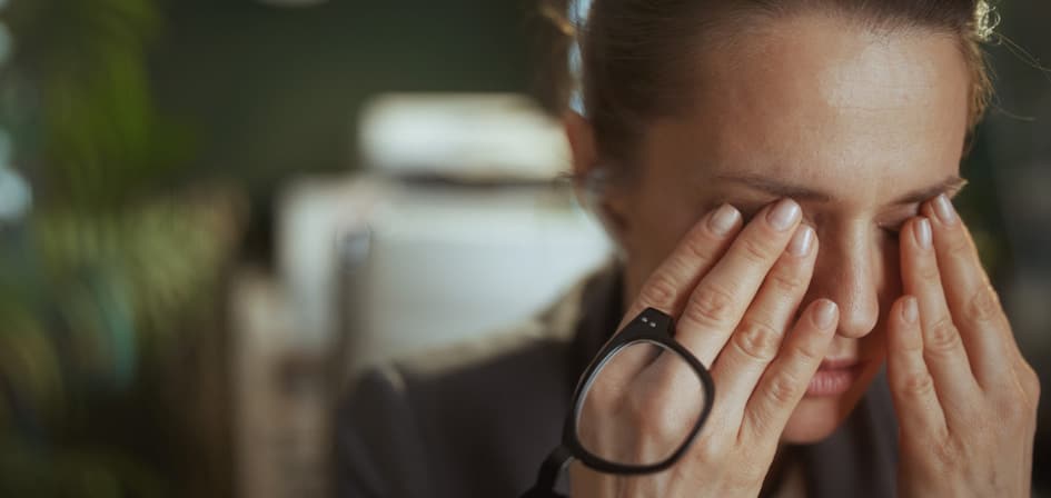 Can Alcohol Cause Blurred Vision? An image of a woman rubbing her eyes