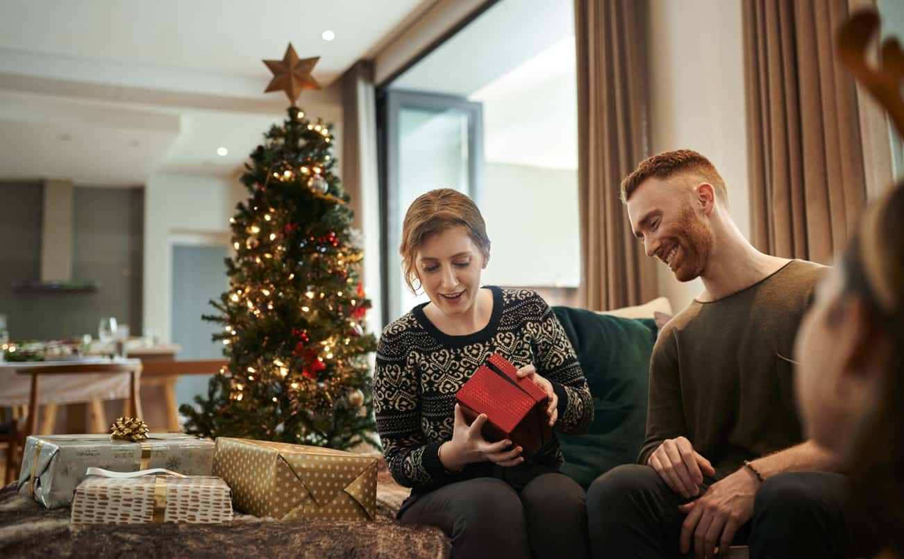 Couple opening presents at Christmas managing mental health