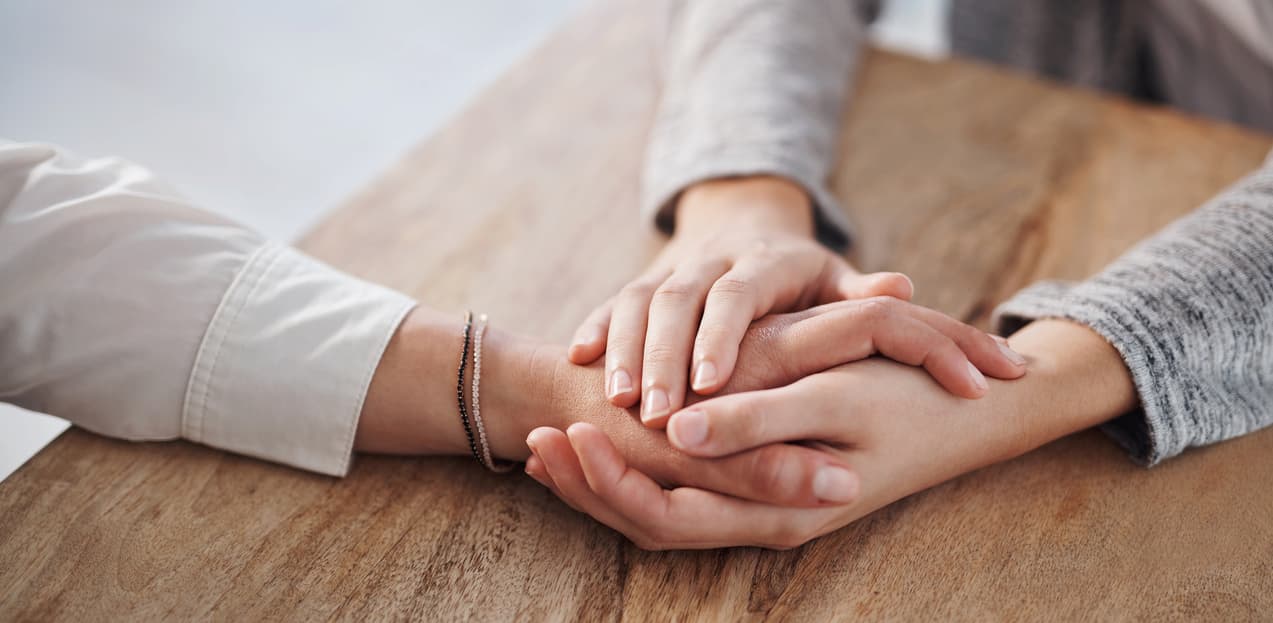 Addict who has relapsed holding hands with family member