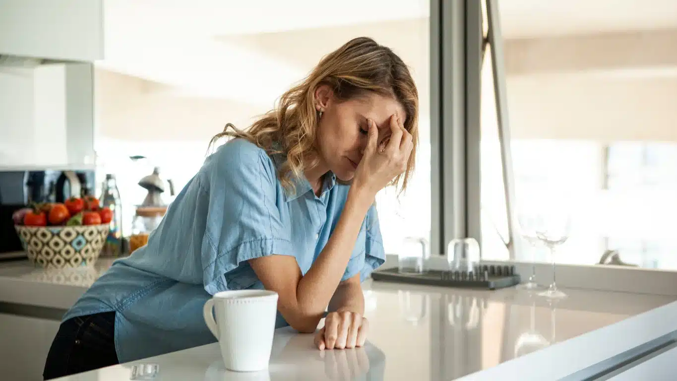 What is Cold Turkey? An image of a woman with a headache, leaning on her kitchen counter.