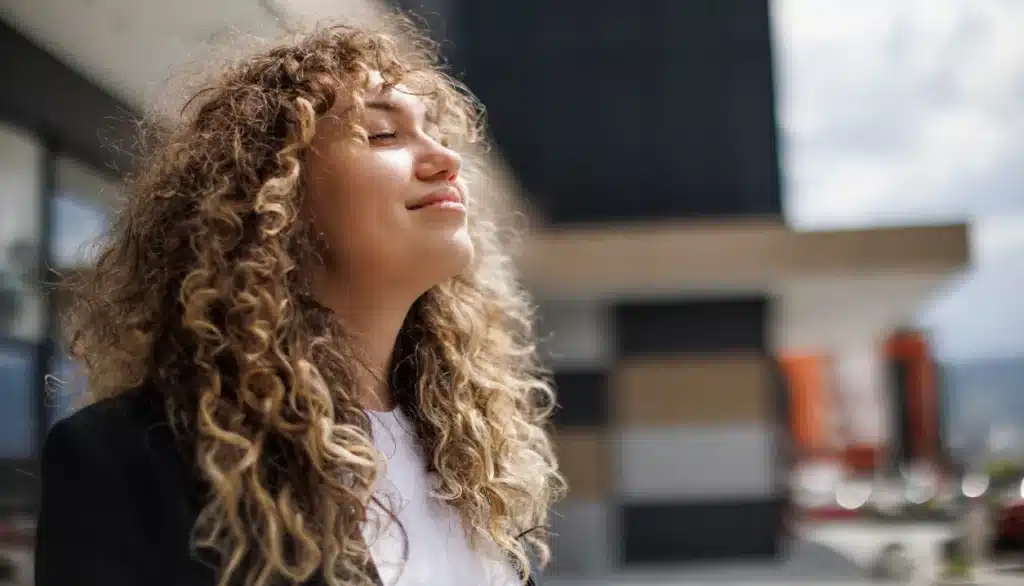 How to Commit to Sobriety. A woman smiling with eyes closed, appearing relieved.