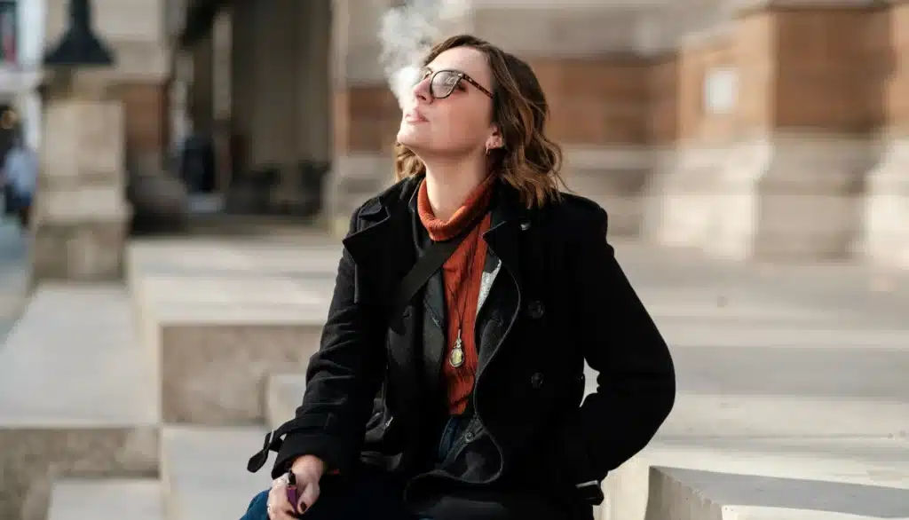 Are vapes being banned in the UK? An image of a woman vaping outside.