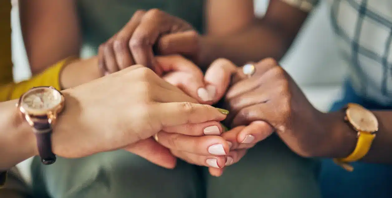 What Role Could AI Play in Treating Addictions? Support group holding hands.