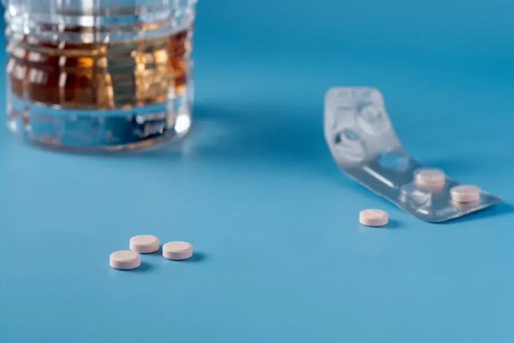 glass of alcohol next to co-codamol pills